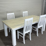 Dining table set with four chairs against a corrugated metal wall. kinloch collection