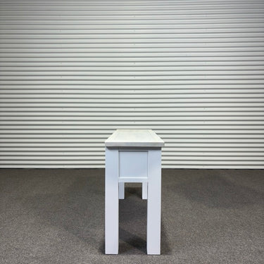 White stool against a corrugated metal wall