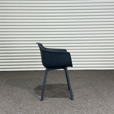 Black chair against a corrugated metal wall.