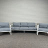 Outdoor furniture set with gray cushions on a metal wall background