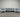 Outdoor furniture set with gray cushions on a metal wall background