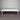 White rectangular table against a corrugated metal wall.