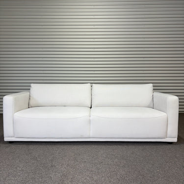 White soft sofa against a metallic wall