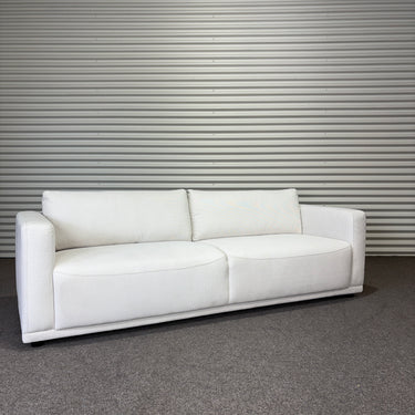 White soft fabric sofa 2 seater against a metallic wall