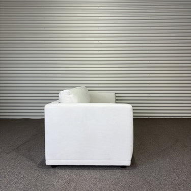 White sofa in a room with a corrugated metal wall.