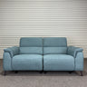 Blue power sofa with black metal legs, against a striped wall