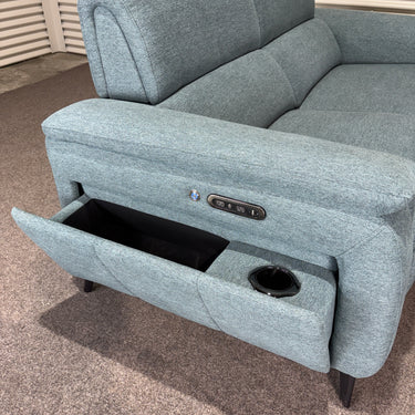 Blue power sofa with black metal legs, against a striped wall