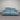 Blue power sofa with black metal legs, headrest extended, against a striped wall