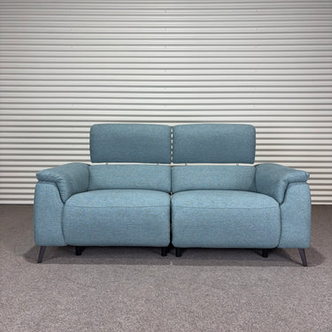 Blue power sofa with black metal legs, extended headrests, against a striped wall