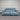 Blue power sofa with black metal legs, against a striped wall
