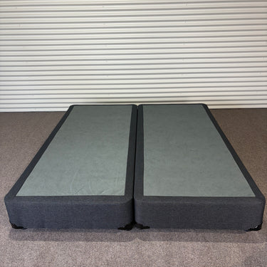 Charcoal fabric, bed base, made in New Zealand, pine wood, corner guard protection, on a gray floor with a striped wall background