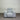 Gray armchair against a corrugated metal wall.