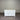 White sideboard with a wooden top against a corrugated metal wall.