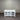 White wooden sideboard with open doors against a corrugated metal wall.
