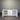 White cabinet with open doors against a corrugated metal wall.