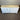 White sideboard with a wooden top against a corrugated metal wall.