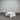 White coffee table with a drawer against a corrugated metal wall.