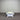 Two white tables against a corrugated metal wall.