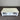 White coffee table with a drawer against a corrugated metal wall.