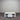 White wooden coffee table with a drawer against a metallic shutter background