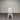 White chair with a gray cushion against a corrugated metal wall.