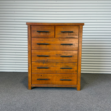 Wooden dresser with multiple drawers against a corrugated metal wall - wanaka collection