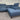 Blue sectional sofa on a gray floor with a corrugated metal wall in the background