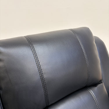 Close up view of padded armrest on black leather manual recliner chair
