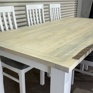 Wooden table with white chairs on a gray surface