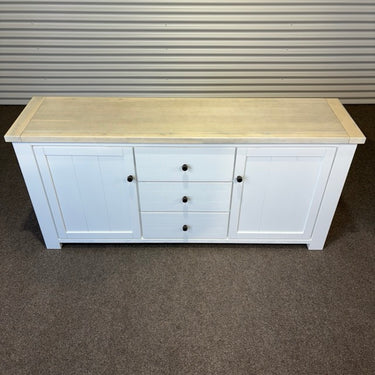 White sideboard with a wooden top against a corrugated metal wall. kinloch collection
