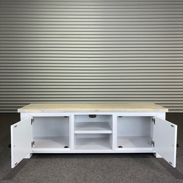 White storage cabinet with open doors against a corrugated metal wall.