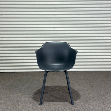Dark gray chair against a corrugated metal wall.