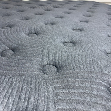 Close-up of Workhorse LUX mattress fabric showing grey textured quilt pattern with circular tufting and swirls