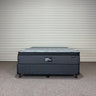 Workhorse LUX mattress with matching base, front view showing quilted top, dark upholstered fabric and brand label against corrugated backdrop